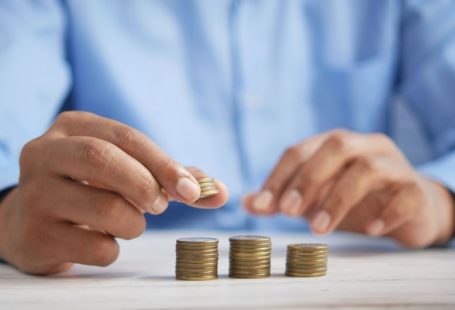 Investment Commodities - a person stacking coins on top of a table